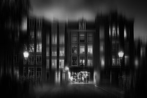 Cosy coffeehouse at Prinsengracht, illuminated at blue hour, old lanterns on the brindge, Amsterdam, Netherlands, black and white